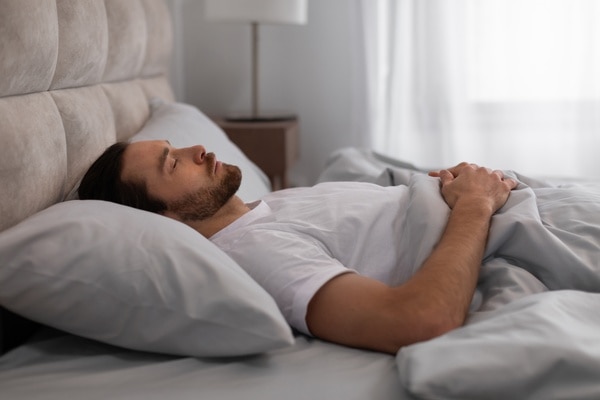  Man som sover på rygg, med kudde