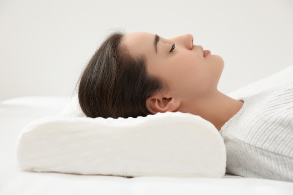  Kvinna som sover på rygg med specialkudde