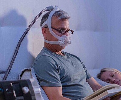 AirFit F30i helmask med luftslangen uppe på hjässan på resande fot